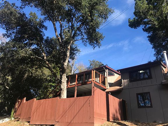 View of front door from upstairs deck. Paved private parking below & large newly paved driveway to the left of home with entrance to enclosed garden.