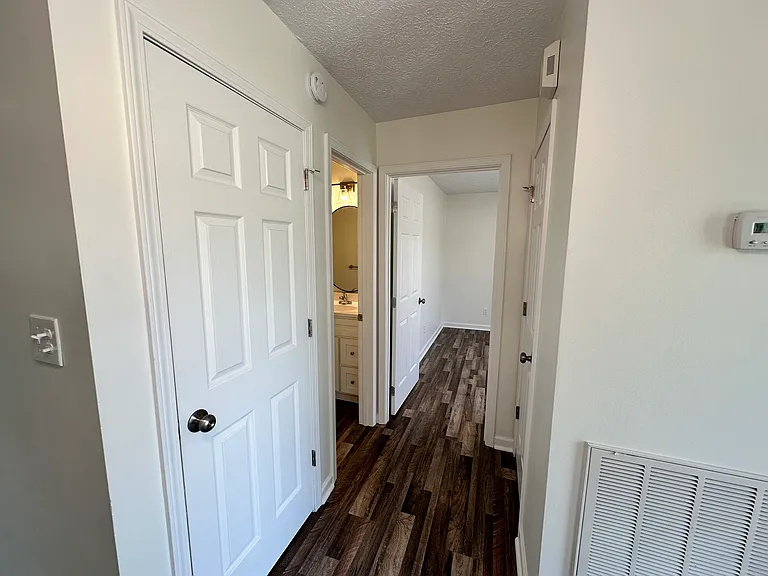 Hallway into the second bedroom and second bathroom with coat closet