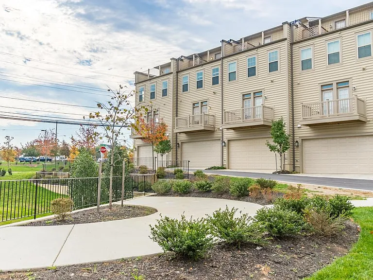 Backing to community landscaped resting area. The townhouse located second left with a two-car garage.