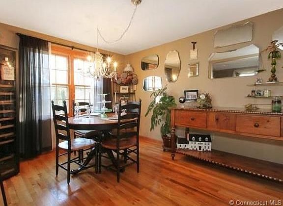 The dining room is open to the living room -- notice the gleaming hard wood floors.  Neither chandelier or huge wine frig do not convey; however, you can tell a lot of fun has been had here.  You are next.