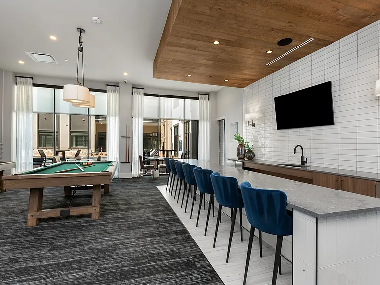 Bright Resident Entertainment Room with Pool Table and Bar for Socializing and Play
