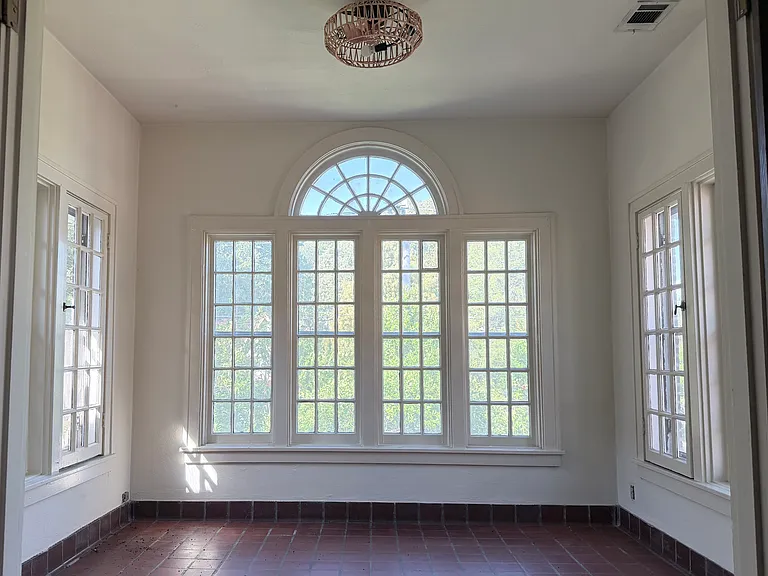Spacious sun room with 3 walls of windows.