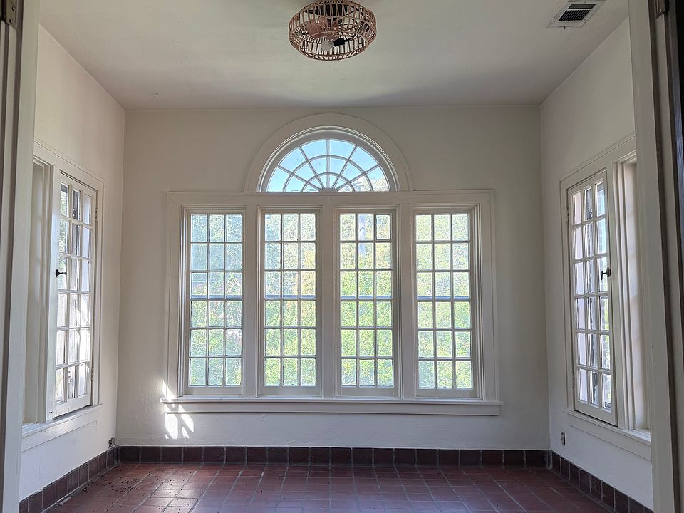 Spacious sun room with 3 walls of windows.