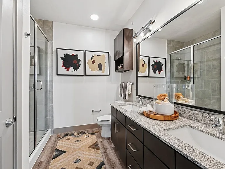 Bath with espresso cabinetry, speckled granite countertops, and hard surface flooring