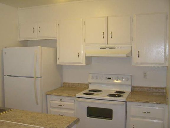 Fridge & stove area. Freshly painted cabinets