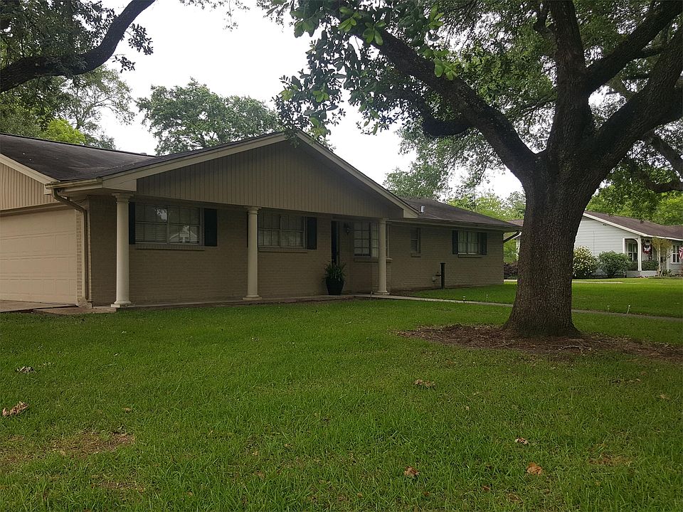 Front yard, large trees surround the home