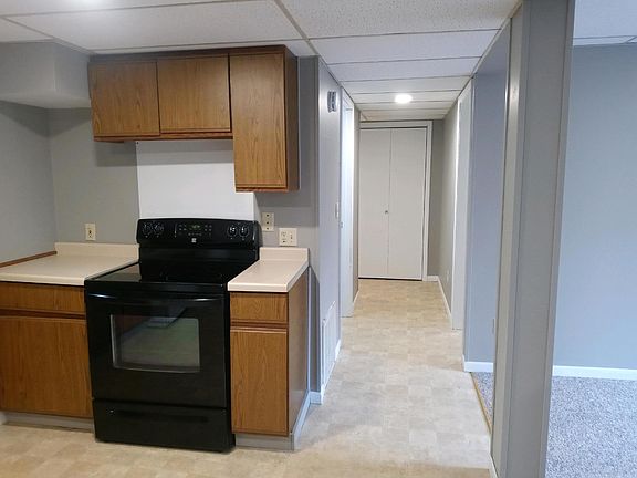 Hallway to bathroom, bedroom, and entry. Living room with large window to the left of photo.