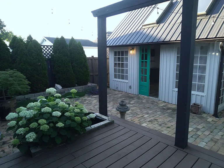 Back deck with brick patio and studio space.