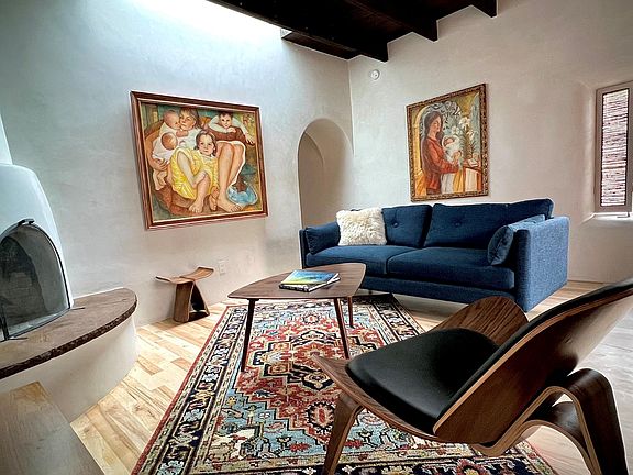 Living room with exposed beam ceiling, skylight, and fireplace