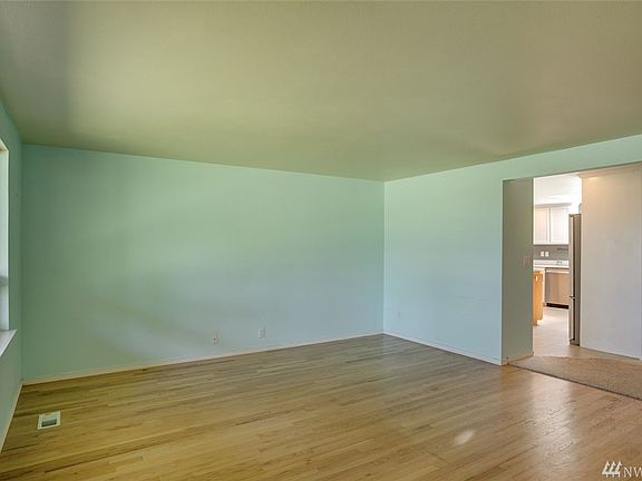 The living room offers a large picture window and hardwood floors.