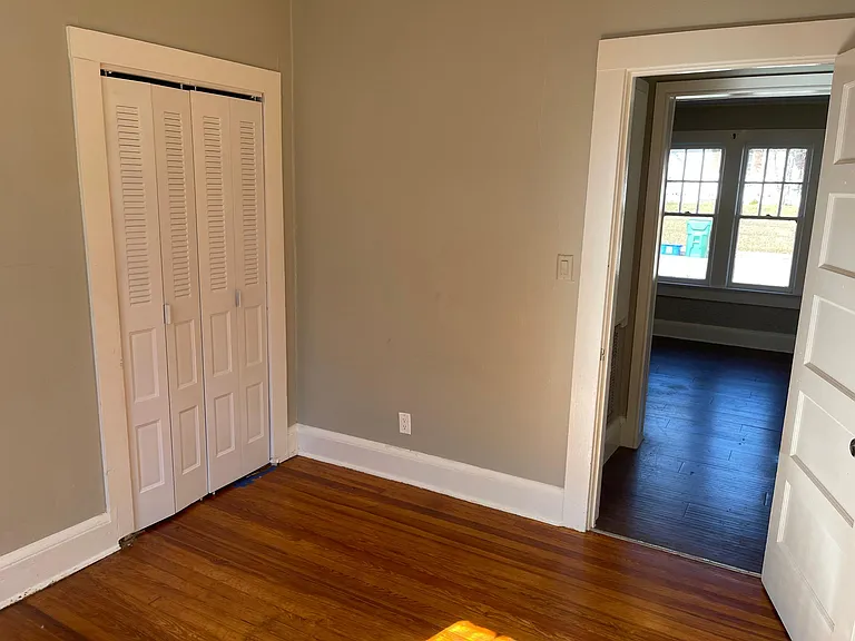 Middle bedroom with refinished hardwood floors .