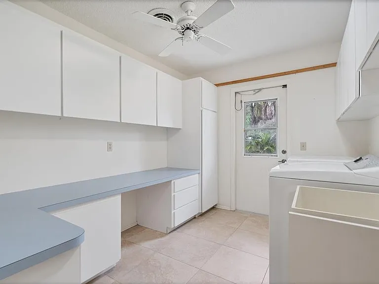 Laundry w/washer, dryer, utility sink, large counter, and north side entry door.