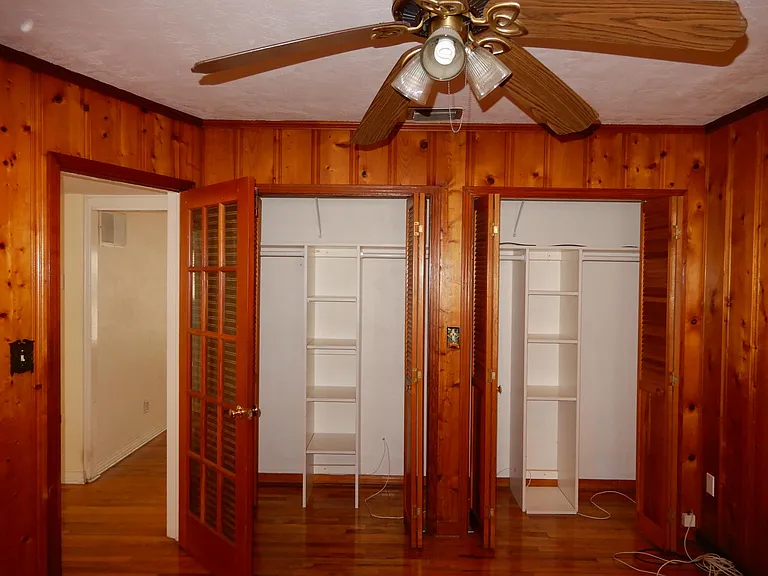 Bedroom #3 with custom shelving system with wall to wall closet.