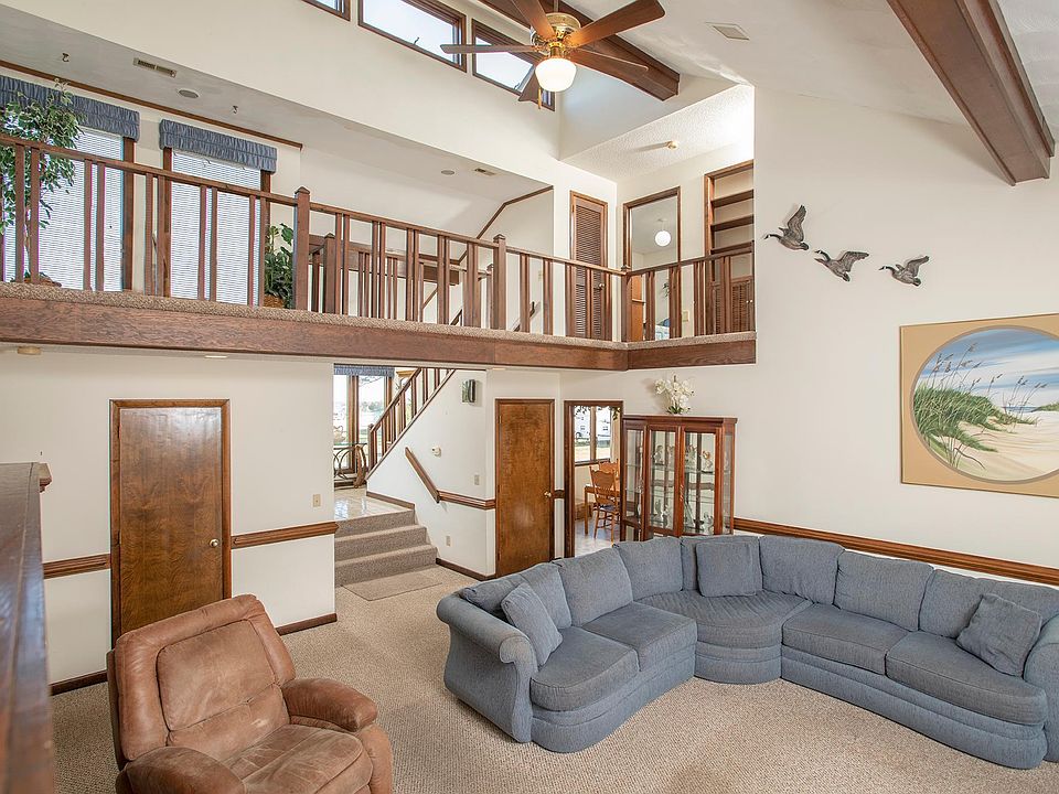3 story Cathedral Living room with second story balcony, and stairs up to the entrance foyer.