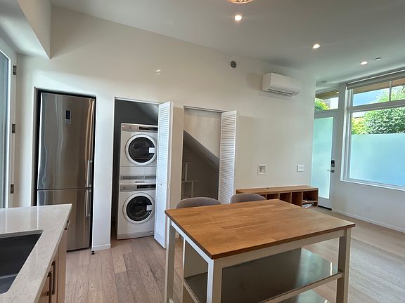 Kitchen (foreground), fridge, laundry and storage; living room to the right