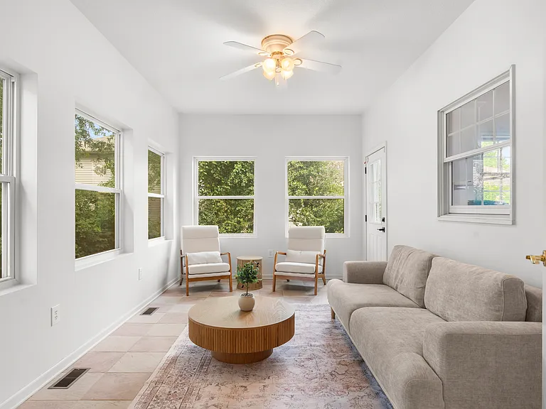 Bright sunroom with comfortable seating and plenty of natural light for relaxing or enjoying morning coffee.