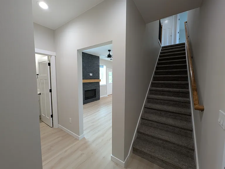 Stairwell, facing Living Room, downstairs half bath, and entry closet.