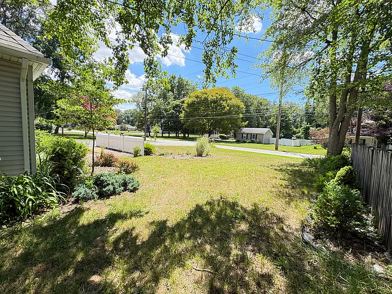 Evergreens along the front fence add year-round beauty and enhance the home's welcoming curb appeal.