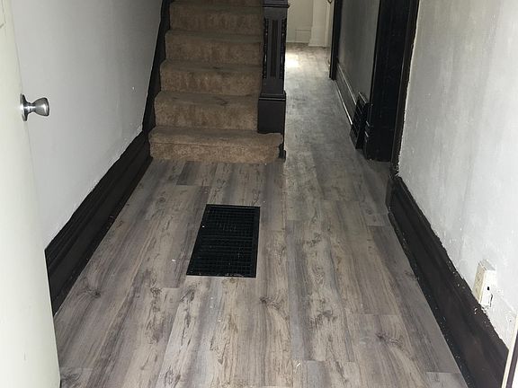 Entry way and hallway leading upstairs and to kitchen, dining room, and living room.