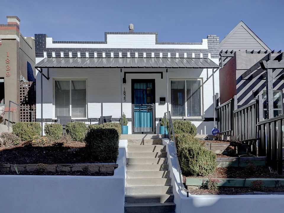 Front of house with patio chairs and table.