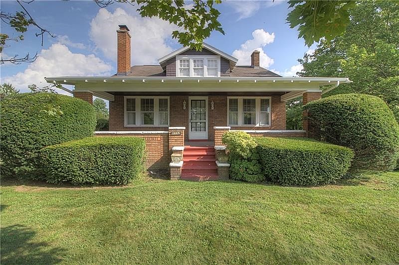 Handsome brick home with an inviting concrete sitting porch, wide overhang on its own lot.