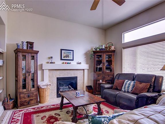 Family room with gas fireplace, ceiling fan, built-ins.
