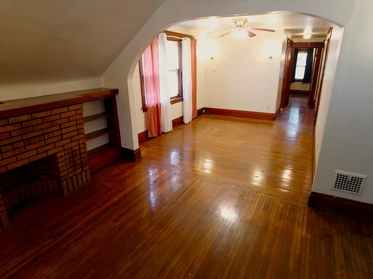Living room looking into the dining room area. Original hardwood floor.