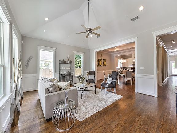 Stunning vaulted ceilings in the Living Room offers an open feel. View into the Dining Room and Kitchen showing the seamless flow.