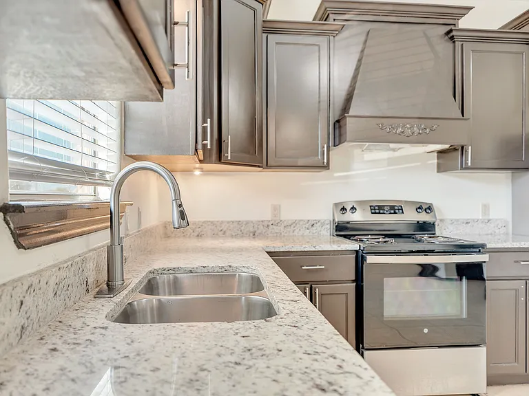 Contemporary kitchen in Merida Vista Apartments showcasing stainless steel appliances and polished granite countertops