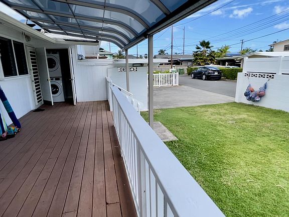 View from the covered lanai (deck) looking onto the front lawn, carport, and side lane.