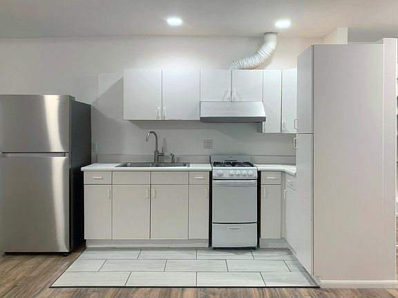 Kitchen w/ & gas oven range and new refrigerator.