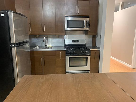 Kitchen with microwave, stove oven, refrigerator, and counter