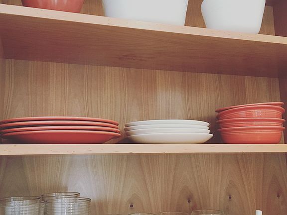 Open shelving in the kitchen stocked with dishes and glasswa