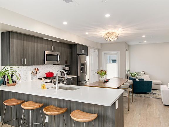 Open kitchen and bar area. Gas stove top, microwave and convection oven. Door on the north side opens to balcony.