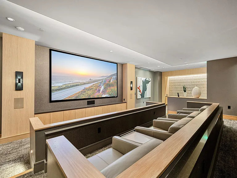 Private theater room with oversized screen and leather seats