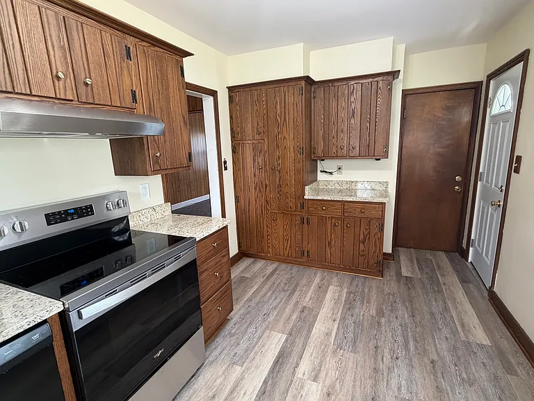 Kitchen - new flooring and new side door, abundant cabinet space. Basement entrance door.