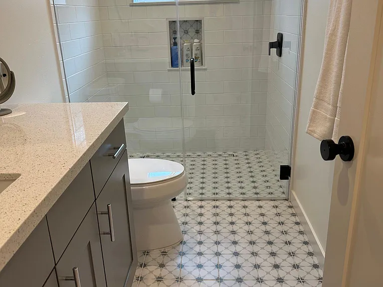 Newly remodeled, new plumbing, tile, fixtures, glass doors, cabinetry!'
no Curb' shower walk-in. Fresh tile, new cabinets and all new plumbing.