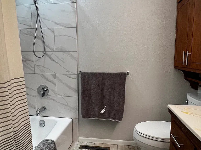 Upstairs hall bathroom with tub/shower combo and upgraded exhaust fan with built-in Bluetooth speaker.