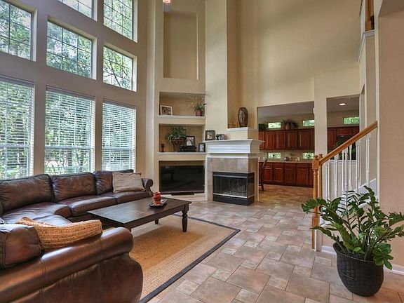 High volume ceilings, art niches, gas fireplace, tile flooring and beautiful views of the wooded landscape.