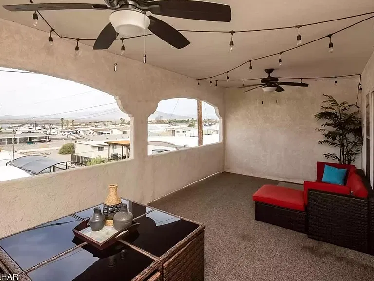 Furnished balcony with ceiling fans.