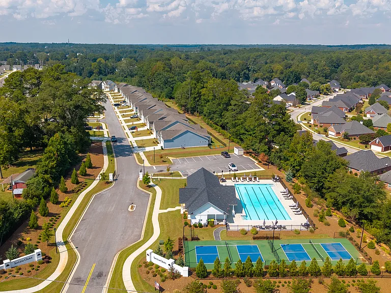 Bird's-eye view capturing the clubhouse, community amenities, and surrounding homes.