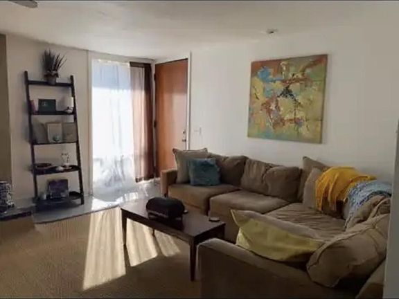 this large living room has three floor two ceiling windows, fireplace, and drop down movie screen room is large enough for two seated areas