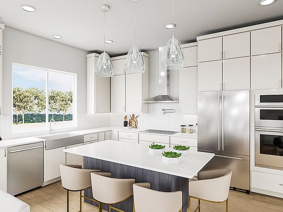 A modern, bright, and spacious kitchen with white cabinets, stainless steel appliances, and a centra