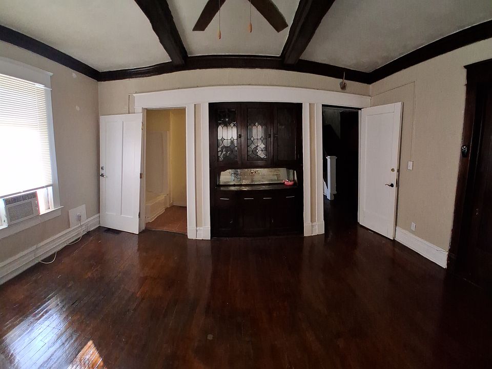 View of the south end of the room with bathroom on the left and door to the hallway on the right.