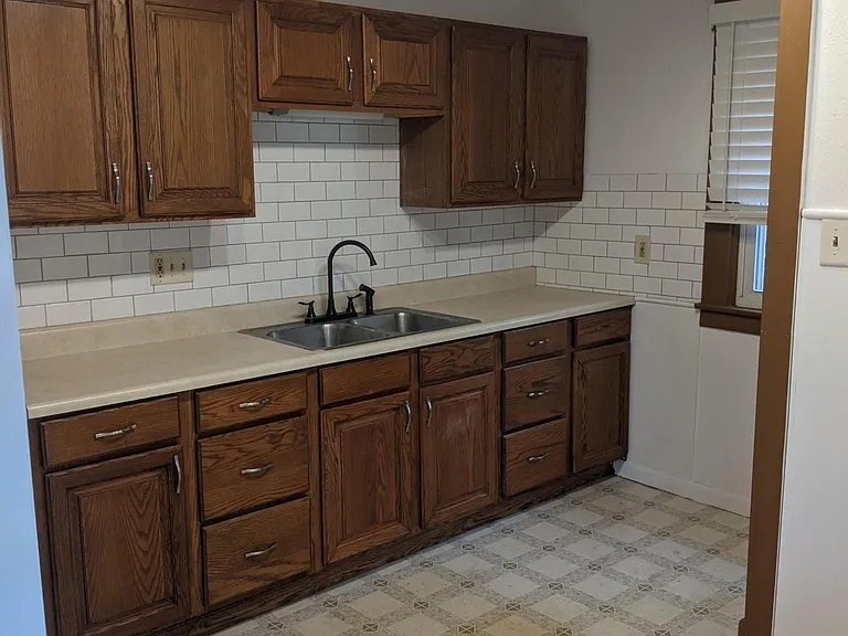 New back splash and blinds in kitchen. Large window overlooking backyard.