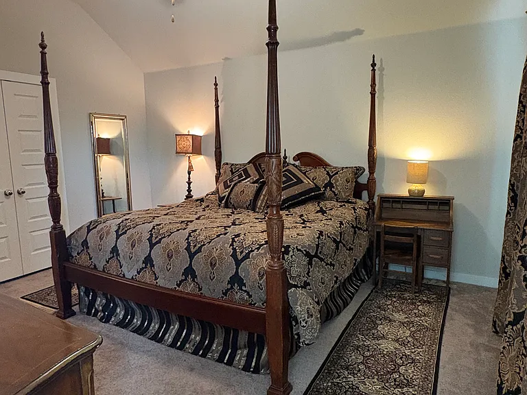 This primary bedroom holds a king size bed, 2 nightstands and 2 dressers.