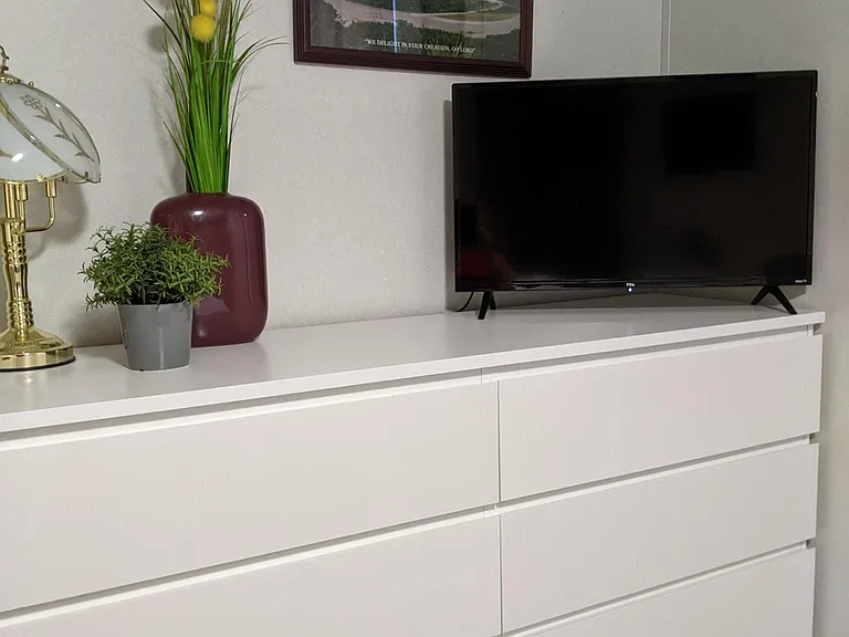 Dresser and smart tv in queen bed room