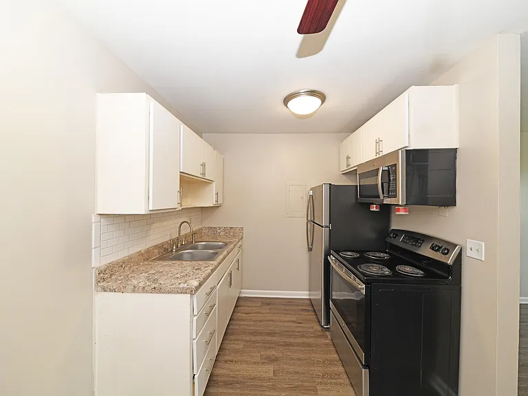 Kitchen area with stainless appliances and hardwood-style flooring