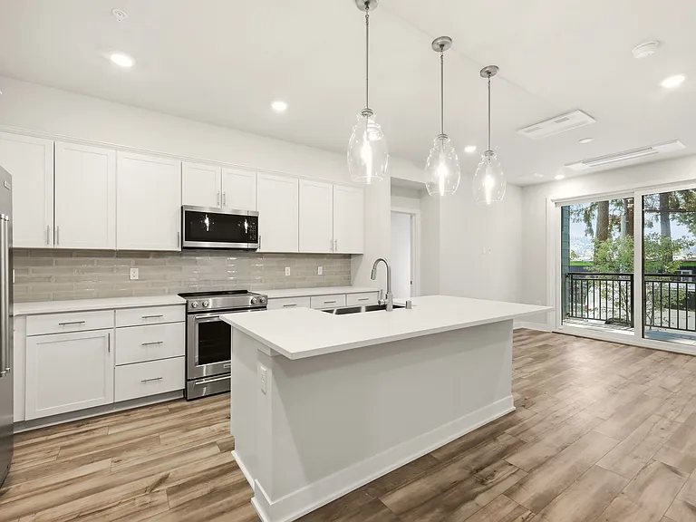 Kitchen with Quartz Countertops, Tile Backsplash, Stainless Steel KitchenAid Appliances, Modern Drop Lights, Eating Area/Breakfast Bar