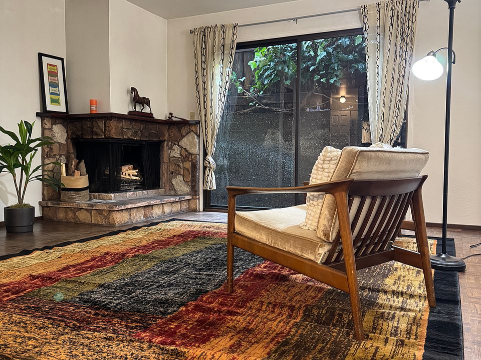 Living room with hardwood floor, working fireplace and sliding glass doors to a small patio